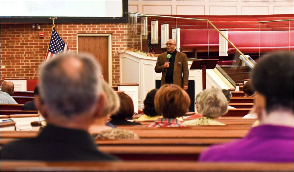 A man giving a sermon in a Baptist church in Arlington, TX.